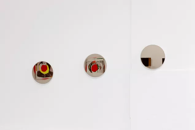 Three round paintings on a wall. Photo. 
